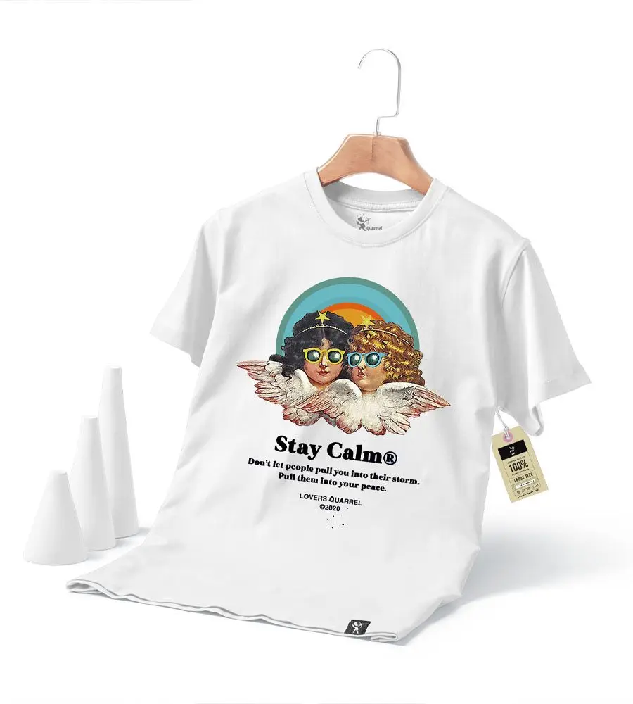 White t-shirt on a hanger featuring two illustrated children, one angelic, with a rainbow background and the text: "Stay Calm. Don't let people pull you into their storm. Pull them into your peace." Crafted with custom screen printing and embroidery services for a unique touch.