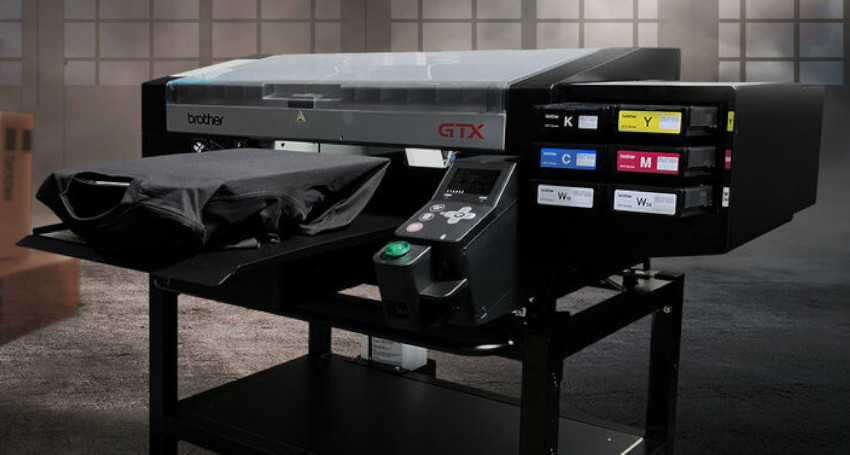 A brother gtx direct-to-garment printer, discovering types of print with a black t-shirt loaded for printing, displaying large ink cartridges labeled with colors.