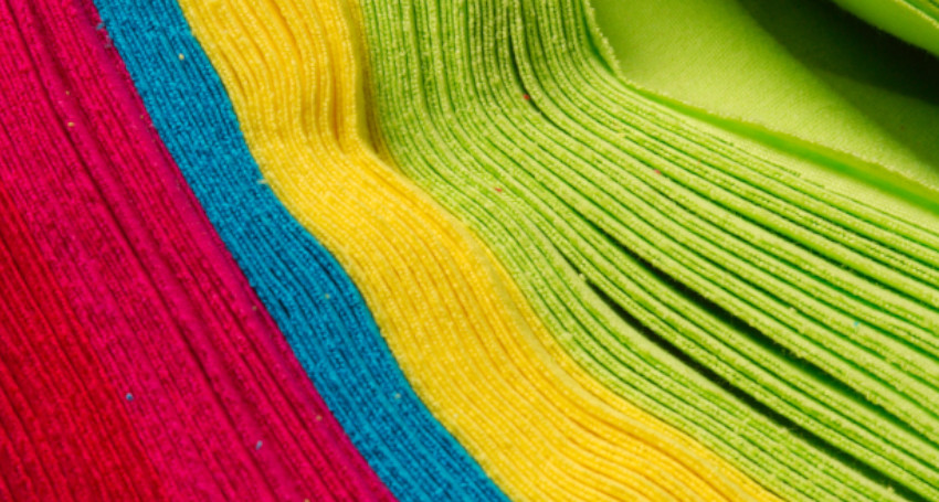 Close-up of a vibrant, multicolored fabric with discovering types of print lines in pink, blue, yellow, and green.