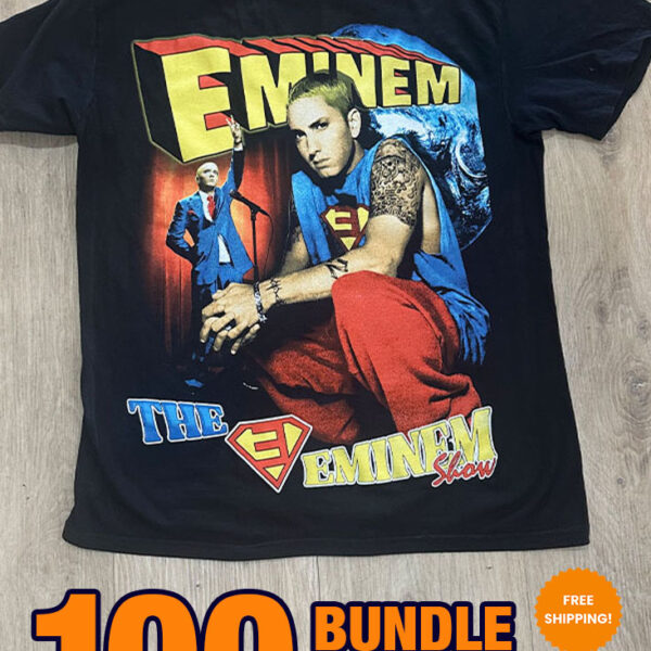 36 Custom Streetwear T-Shirts – Heavyweight Garment-Dyed Cotton displayed on a wooden surface. Text on the T-shirt includes "Eminem" and "The Eminem Show," featuring an image of the artist. Text overlay advertises a sale: "100 BUNDLE $18.95 PER FREE SHIPPING!.