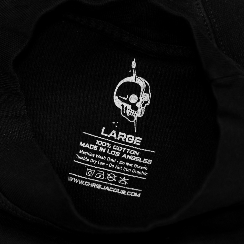 Custom screen printed neck tag on a 100% cotton t-shirt that shows the clothing brand's information in gray ink.