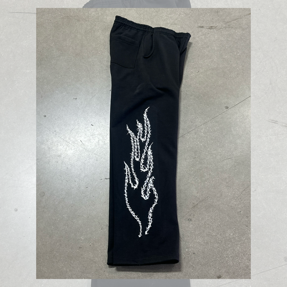 This is a photo of custom screen printed black joggers with white plastisol ink on the side for our clothing brand customer.