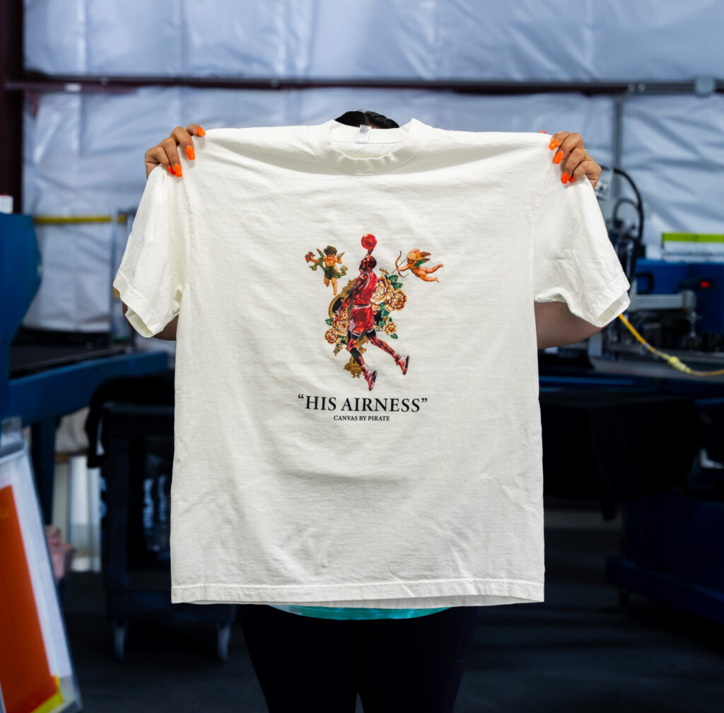 This is a custom Los Angeles Apparel 1801GD t-shirt in off white color that features a digital screen printing design on the front in full color.