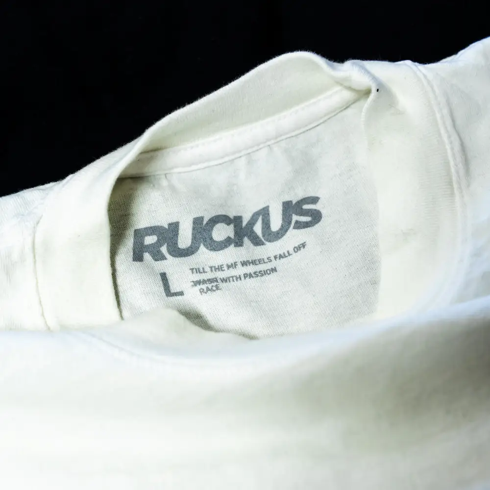 Close-up view of the grey neck label a white Los Angeles Apparel 1801GD 6.5oz Garment Dye Crew Neck T-Shirt featuring detailed digital squeegee printing of Garment Decor