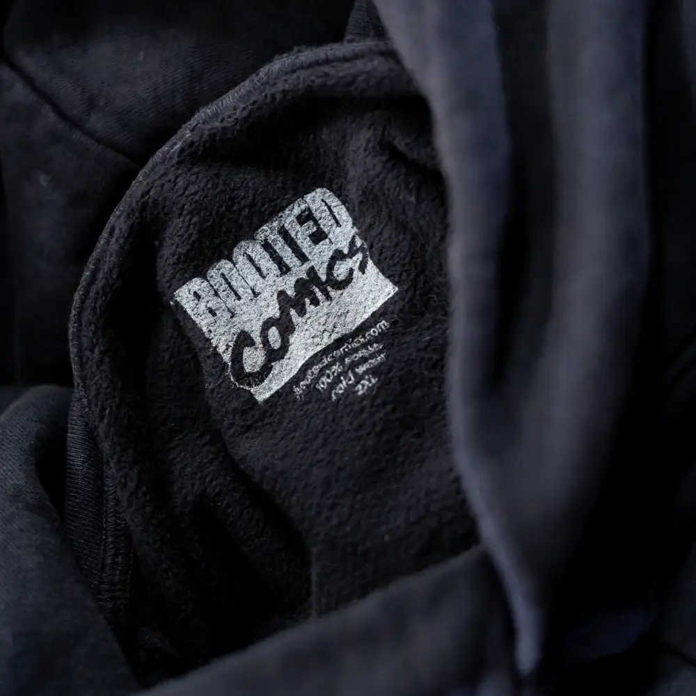 Close-up view of the neck label on a Los Angeles Apparel HF-09 L/S HEAVY FLEECE HOOD PO 14 OZ with custom branding.