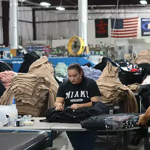Photo of Garment Decor's factory with an employee folding t-shirts